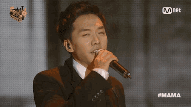 a man singing into a microphone with the hashtag #mama on the bottom right