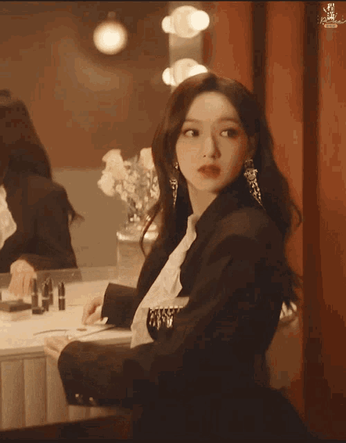 a woman sitting in front of a mirror with a reflection of herself in the mirror