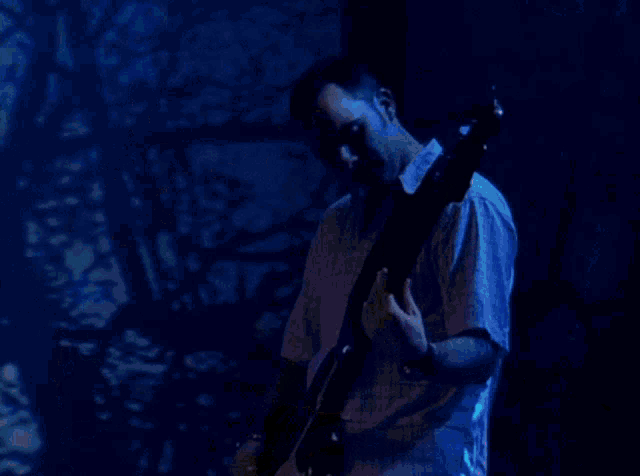 a man is playing an acoustic guitar on stage