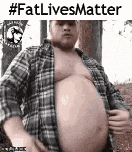 a man with a very large belly is wearing a plaid shirt and standing in the woods .