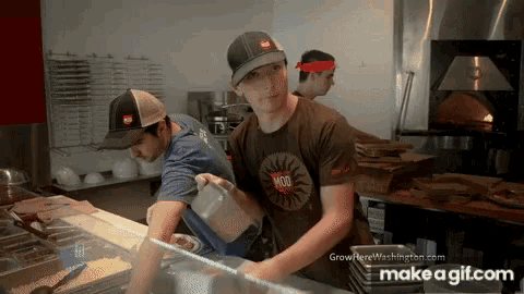 a man wearing a brown shirt that says mod is pouring liquid into a container