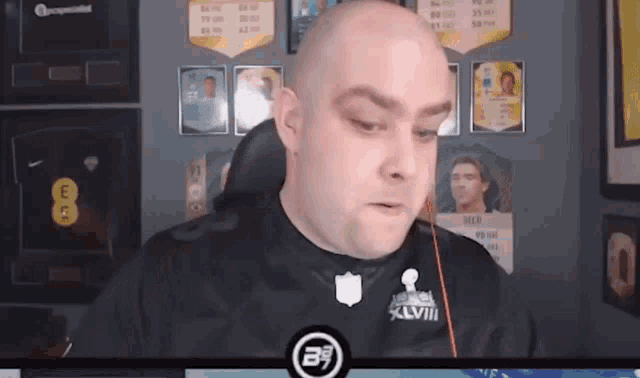 a bald man wearing a super bowl xviii jersey