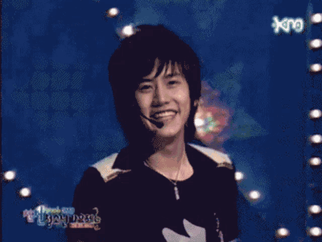 a man in a black shirt stands in front of a blue background with king written on it