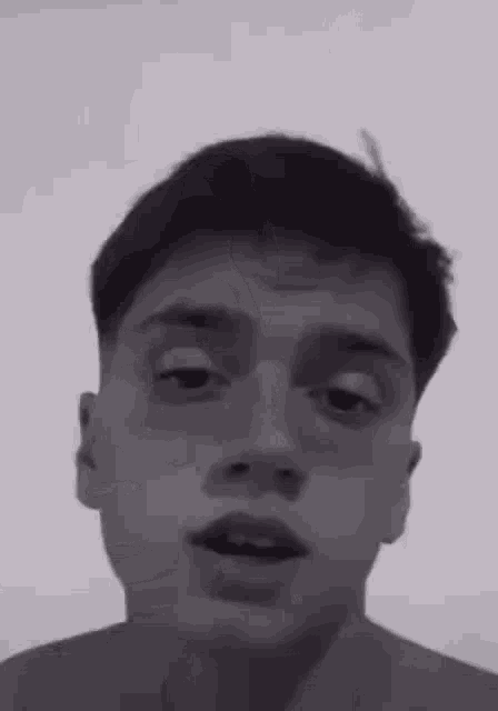 a young man without a shirt is making a funny face .