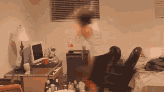 a blurry picture of a person standing in a room with a desk and chair
