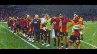 a group of soccer players standing on a field with one player wearing a number 26 jersey