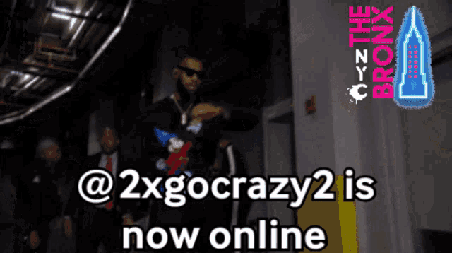 a man is standing in a hallway with the words " @ 2xgocrazy2 is now online " in front of him
