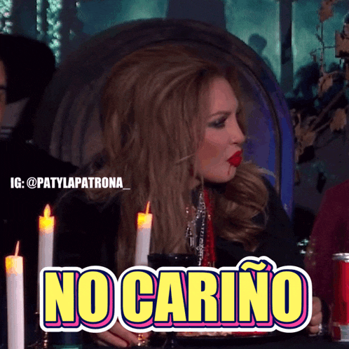 a woman is sitting at a table with candles and a sign that says no carino on it