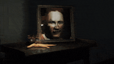 a framed portrait of a man with red hair sits on a table next to carrots