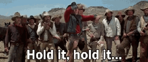 a group of cowboys with the words hold it hold it written below them