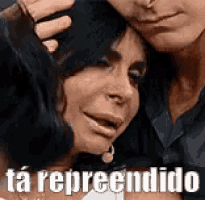 a man and a woman are hugging each other and the woman is crying and the man is putting his hand on her head .