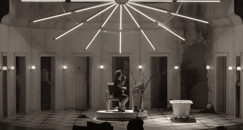 a black and white photo of a person playing a violin on a stage