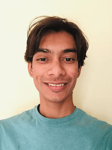 a man in a blue shirt is smiling for the camera