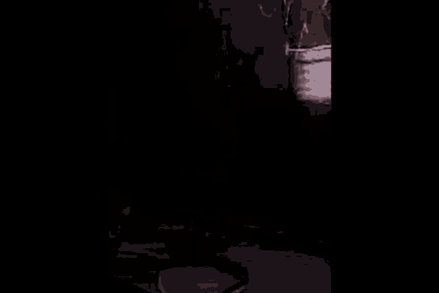 a woman is standing next to a ghost wrapped in a blanket in a dark room .