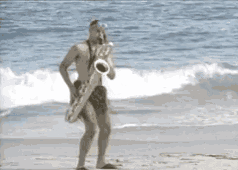 a shirtless man is playing a saxophone on a beach