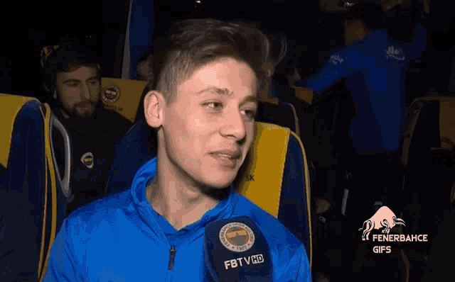 a man in a blue jacket with a fbtv logo on it