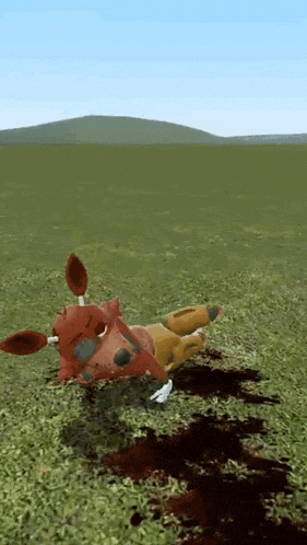 a stuffed animal is laying on its back in a field with blood on the ground .