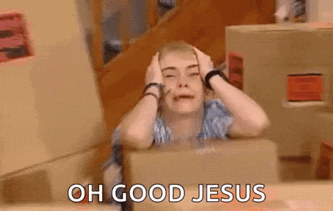 a woman is sitting in front of a box and holding her head .