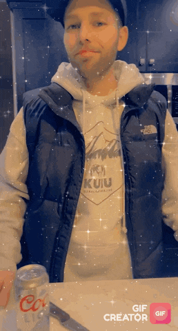 a man wearing a the north face vest is holding a coke can