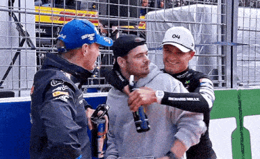 a group of men standing next to each other on a race track .