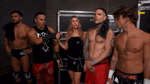 a group of wrestlers are standing next to each other in front of a case that says ntt