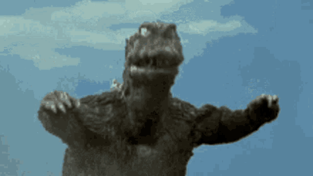 a monster with its arms outstretched is standing in front of a blue sky