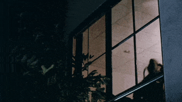 a dark room with a reflection of a person in the window