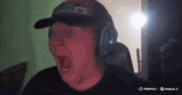 a man wearing headphones and a baseball cap is making a funny face