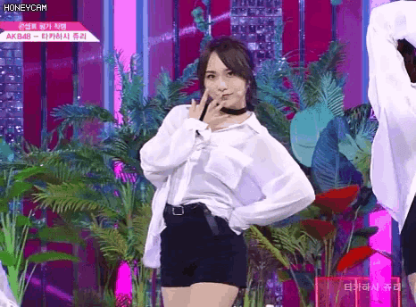 a woman in a white shirt and black shorts stands on a stage