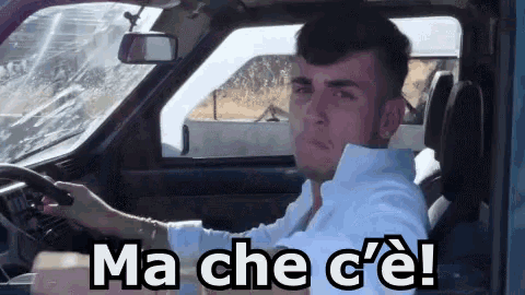 a man is driving a car with the words ma che c'e written on the side