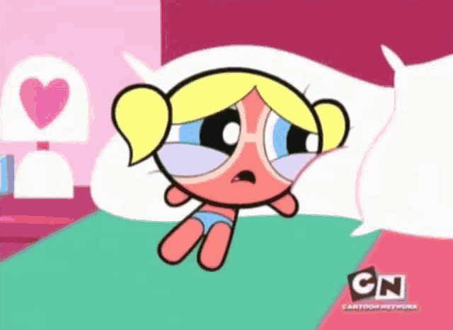 bubbles from the powerpuff girls is sitting on a bed
