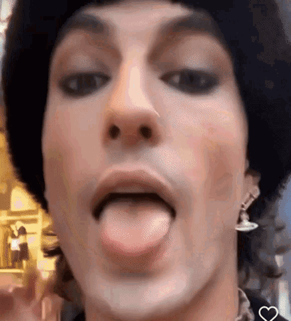 a close up of a man 's face with his tongue out .