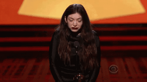 a woman is kneeling down in front of a microphone .