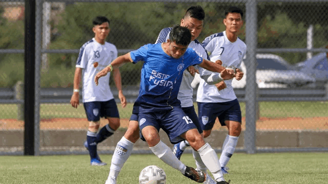 a group of soccer players are playing a game and one player has the number 15 on his jersey