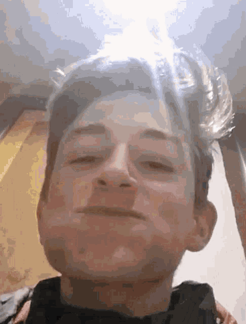 a young man is making a funny face with his eyes closed .