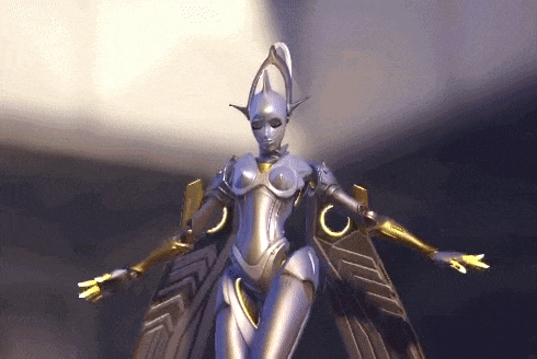 a statue of a robot with wings is standing in a dark room .