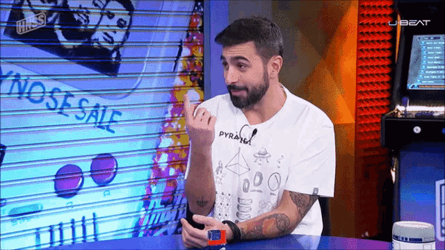 a man with a beard wearing a white shirt that says pyraffel