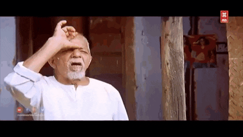 a man with a beard is making a funny face while holding his hand to his forehead .