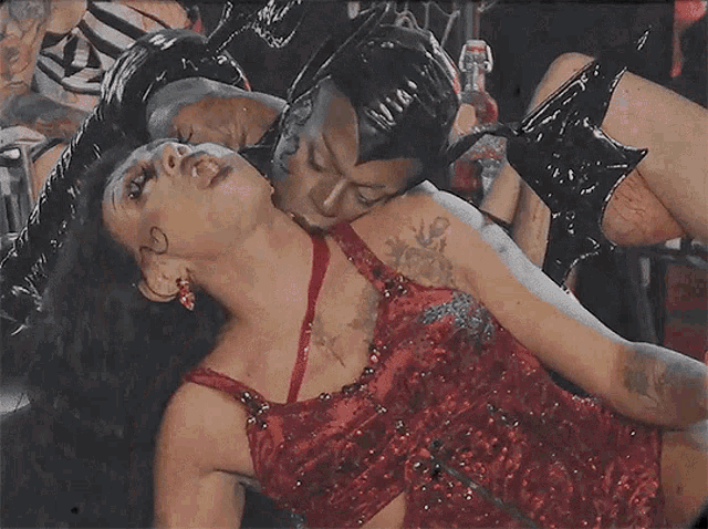 a woman in a red dress is laying on a man 's chest