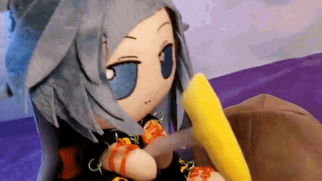 a stuffed doll with blue eyes is holding a yellow object