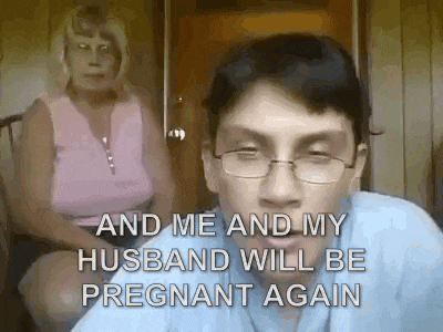 a man wearing glasses is sitting in front of a woman who is sitting on a chair .