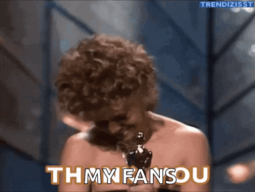 a woman with curly hair is holding an oscar and says thmy fansou
