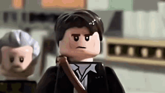 a lego man in a suit and tie is standing next to another lego man in a suit and tie .