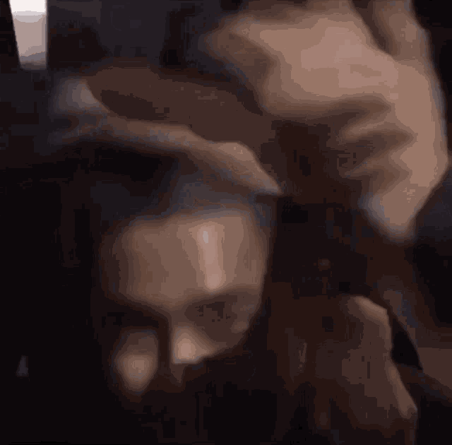 a close up of a person 's face with a person 's hand covering it .