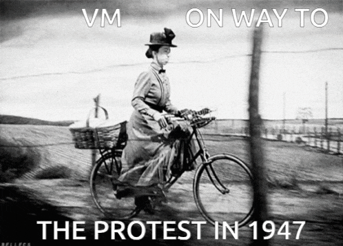 a black and white photo of a woman riding a bike with the words vm on way to the protest in 1947 below her