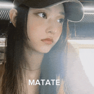 a close up of a woman wearing a hat with matate written on it