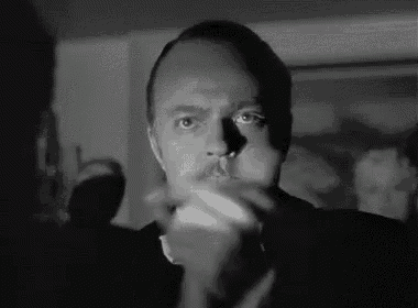 a black and white photo of a man with a mustache holding a cigarette in his mouth .