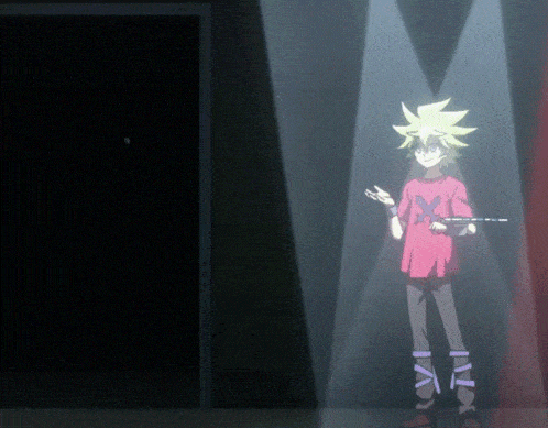 a boy in a red shirt with the letter x on it stands in a dark room