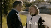 a man and a woman are standing next to each other on a sidewalk .