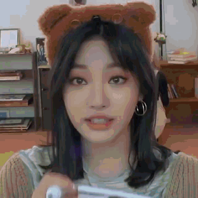 a young woman wearing a teddy bear hat is holding a toothbrush .